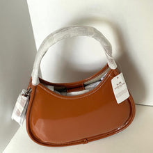Load image into Gallery viewer, Brown handbag with a visible brand tag on a white surface