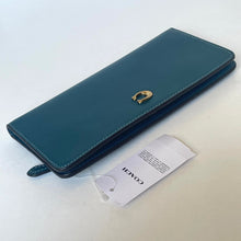 Load image into Gallery viewer, Teal wallet with a brand tag on a light gray background