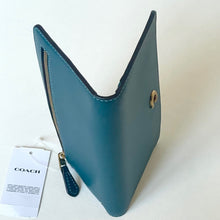 Load image into Gallery viewer, Blue leather wallet with gold accents on a white background, featuring a Coach tag.