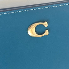 Load image into Gallery viewer, Gold earring on a blue leather surface