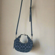 Load image into Gallery viewer, Blue handbag with a strap on a light beige background