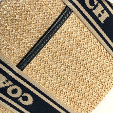 Load image into Gallery viewer, Close-up of a textured surface with 'Coach' branding