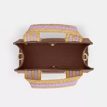 Load image into Gallery viewer, Brown handbag with pink and yellow woven handles on a white background