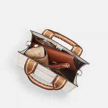 Load image into Gallery viewer, Brown handbag with a white interior on a light gray background