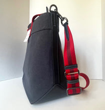 Load image into Gallery viewer, Black bag with a red and black striped strap on a white background