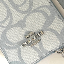 Load image into Gallery viewer, Close-up of a Coach wallet with logo charm and keychain on a light background