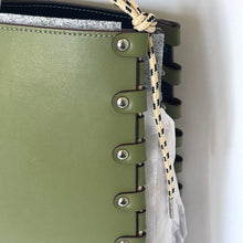 Load image into Gallery viewer, Close-up of a green leather-bound notebook with metal rings and a rope detail.