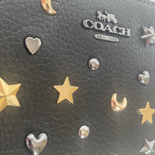 Load image into Gallery viewer, Black Coach handbag with star, moon, and heart embellishments.
