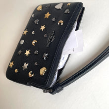 Load image into Gallery viewer, Black studded wallet with stars and moons on a light background