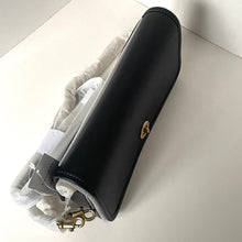 Load image into Gallery viewer, Black leather clutch with gold accents on a light surface