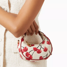 Load image into Gallery viewer, Handbag with cherry design held by a person wearing a white textured garment.