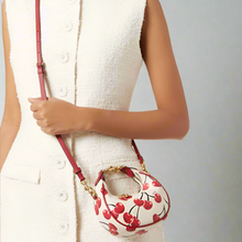 Load image into Gallery viewer, Person holding a handbag with cherry design against a white background