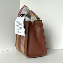 Load image into Gallery viewer, Brown leather handbag with a Coach tag on a white background