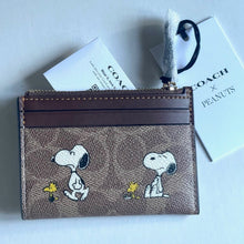 Load image into Gallery viewer, Coach wallet with Snoopy design on a light blue background