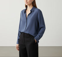 Load image into Gallery viewer, Blue shirt on a hanger against a white background