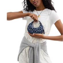 Load image into Gallery viewer, Woman holding a blue handbag with a white background