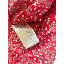 Load image into Gallery viewer, Red fabric with floral pattern and a visible tag.