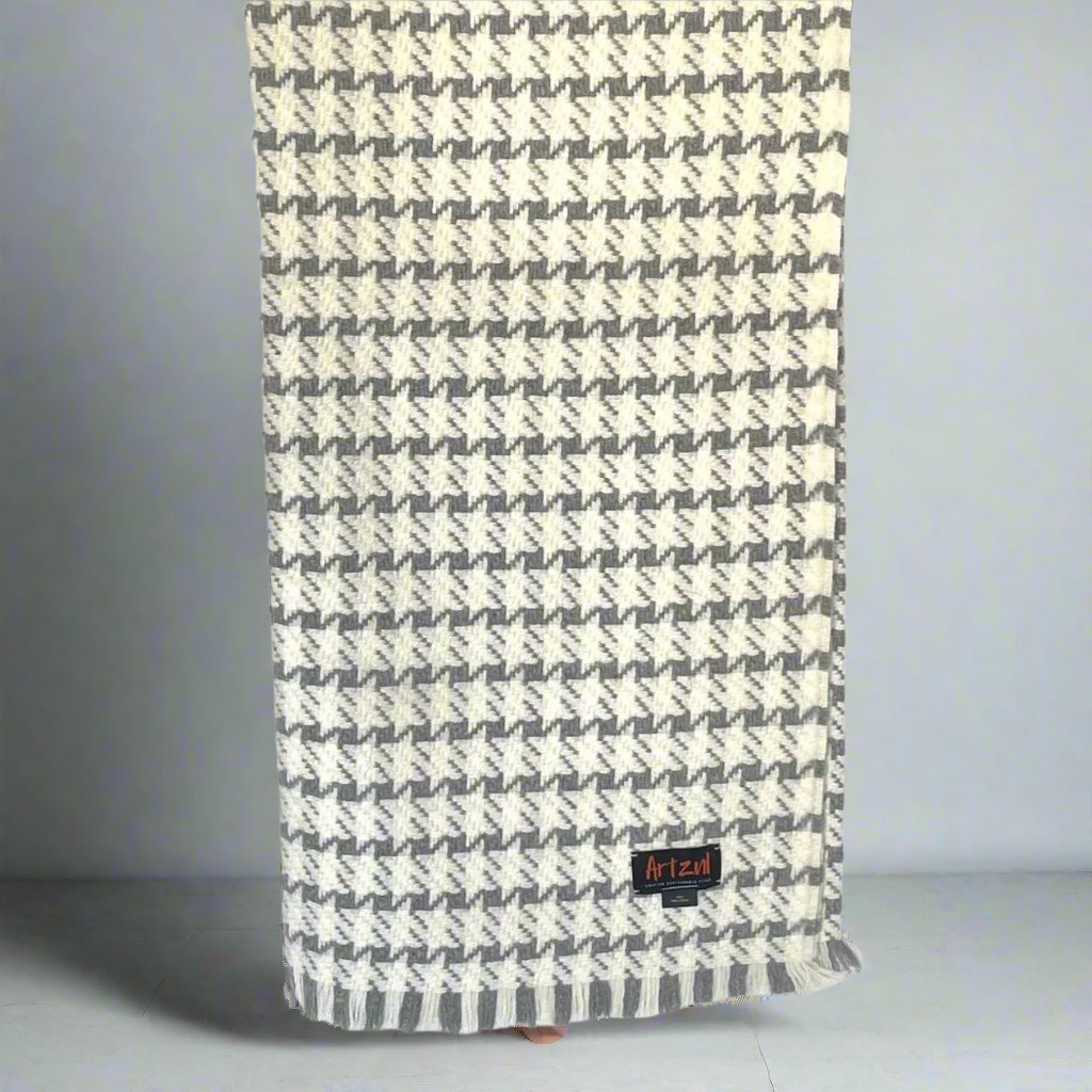 A lightweight, cream and gray houndstooth throw blanket with a fringed edge, displayed on a light background.