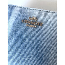 Load image into Gallery viewer, Close-up of a Coach logo on a denim fabric background