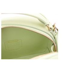 Load image into Gallery viewer, Close-up of a light green leather bag with a visible brand label.