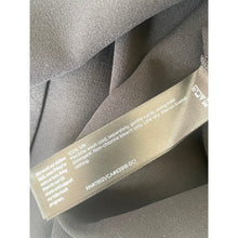 Load image into Gallery viewer, Close-up of a fabric label with washing instructions on a gray background