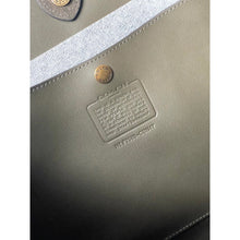 Load image into Gallery viewer, Close-up of a Coach bag with a visible brand logo and text.