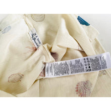 Load image into Gallery viewer, Close-up of a fabric with a label on a white background