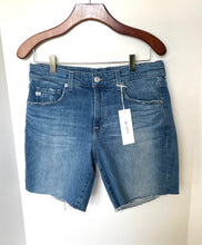 Load image into Gallery viewer, Blue denim shorts on a hanger with a white background