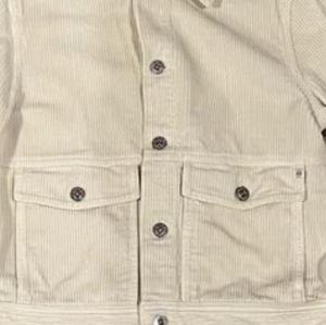 Beige corduroy jacket on a wooden surface