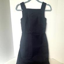 Load image into Gallery viewer, Black dress on a hanger against a white background