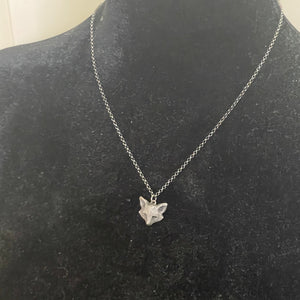 Silver necklace with a fox pendant on a black mannequin bust.