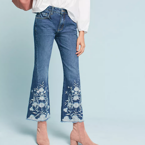 Flared jeans with floral embroidery on a light blue background