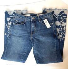 Load image into Gallery viewer, Folded blue jeans with floral pattern on a white background
