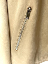 Load image into Gallery viewer, Close-up of a beige suede or faux-suede jacket with a diagonal silver zipper pocket and a silver zipper pull.