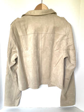 Load image into Gallery viewer, A light beige suede jacket with a wide collar, shown from the back and hanging on a wooden hanger against a white background.