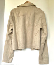 Load image into Gallery viewer, A cropped beige faux-leather jacket with a collar, hanging on a wooden hanger against a plain off-white background.
