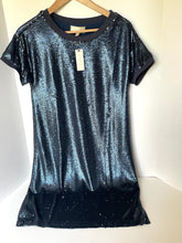 Load image into Gallery viewer, A short-sleeve sequined t-shirt dress in a dark blue to black ombre gradient, hanging on a wooden hanger against a plain white background.