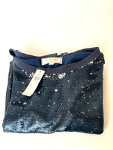 Load image into Gallery viewer, A folded navy blue sequined top with a ribbed collar, featuring a white price tag attached and a brand label inside the collar, set against a plain off-white background.