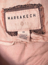 Load image into Gallery viewer, Fabric label with 'Marrakech' branding and size 'XS' on a pink fabric background.