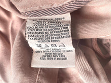 Load image into Gallery viewer, Close-up of a fabric tag on a textured beige background
