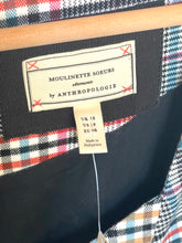 Load image into Gallery viewer, Close-up of a garment's interior neck label reading 'MOULINETTE SOEURS' and 'by ANTHROPOLOGIE', with a plaid lining in red, blue, white, and black visible around the collar.