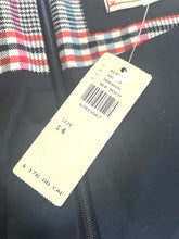 Load image into Gallery viewer, A close-up of a black garment with a red, white, and blue plaid pattern visible at the top, featuring a black zipper and a cream-colored size tag attached.