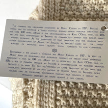 Load image into Gallery viewer, Text label on a knitted product with branding and text details.