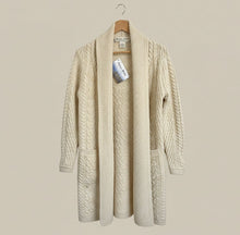 Load image into Gallery viewer, Beige cardigan on a hanger against a white wall