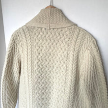 Load image into Gallery viewer, Beige knitted cardigan on a hanger against a white background