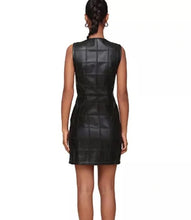 Load image into Gallery viewer, A woman shown from the back wearing a sleeveless black faux-leather mini dress with a quilted grid pattern and structured shoulders, set against a plain white background.