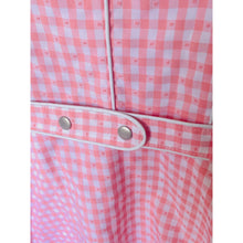 Load image into Gallery viewer, Close-up of a pink and white checkered garment with metal buttons on a white background
