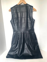 Load image into Gallery viewer, A sleeveless black faux-leather dress with a quilted grid pattern, hanging on a wooden hanger against a plain white background.