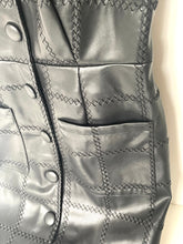 Load image into Gallery viewer, Close-up of a dark gray faux leather vest with diamond-quilted stitching, decorative button details, and front pockets.