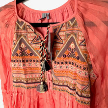 Load image into Gallery viewer, Coral dress with intricate geometric patterns on a hanger